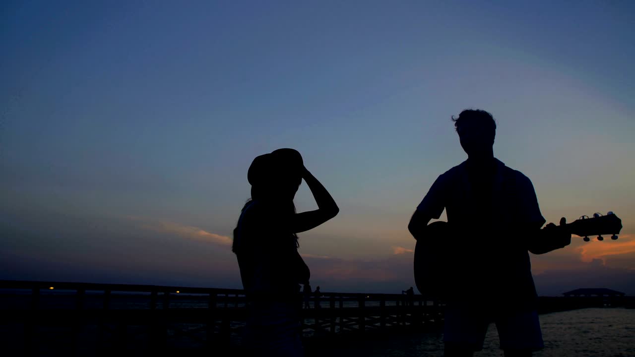 남자 와 여자 가 기타 를 들고 춤추는 실루