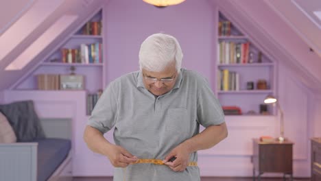 Happy-Indian-old-man-checking-his-waist-size-using-inch-tape