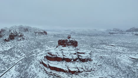 snow-covered bell rock, sedona arizona usa in wintertime. aerial drone shot