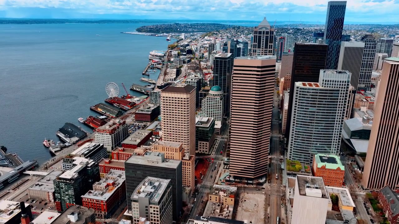 Vivace centro della splendida Seattle, Stato di Washington, USA di giorno. Lungomare della città moderna con architettura variegata, moli e ruota panoramica. Vista dall'alto.