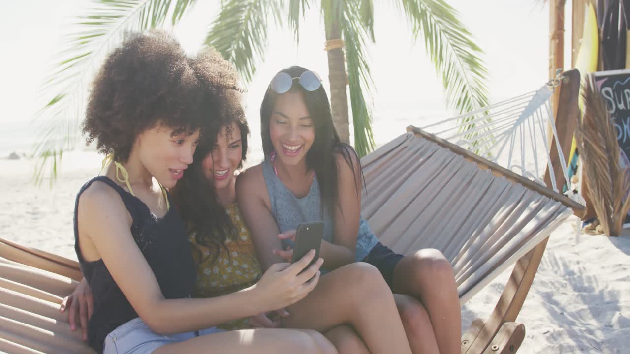 ⁇ 스 인종 친구 들 이 해변 에 있는 해마크 에서 전화 를 보고 있다