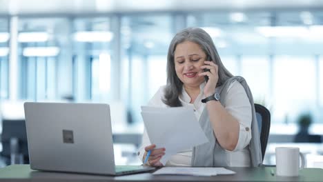 Happy-Indian-senior-female-manager-talking-on-phone