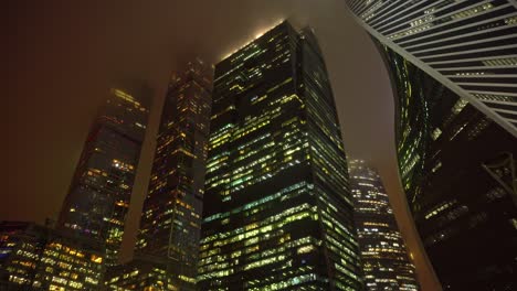 los rascacielos futuristas modernos de moscú el centro de la ciudad de moscú en la niebla por la noche, una vista ominosa de las torres del cielo de moscú y el centro de negocios