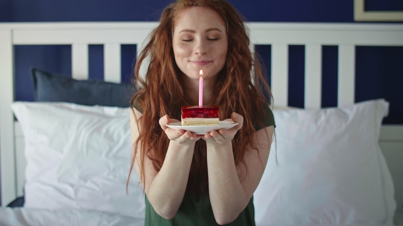 zoom out video de mujer soplando una vela de cumpleaños