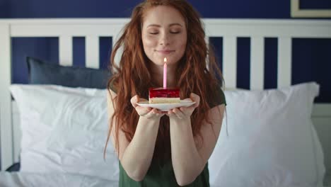 zoom out video of woman blowing a birthday candle