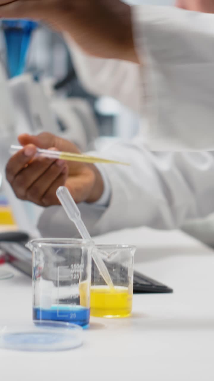 Vertical video Histology chemist conducting pipetting operation for chemical liquids