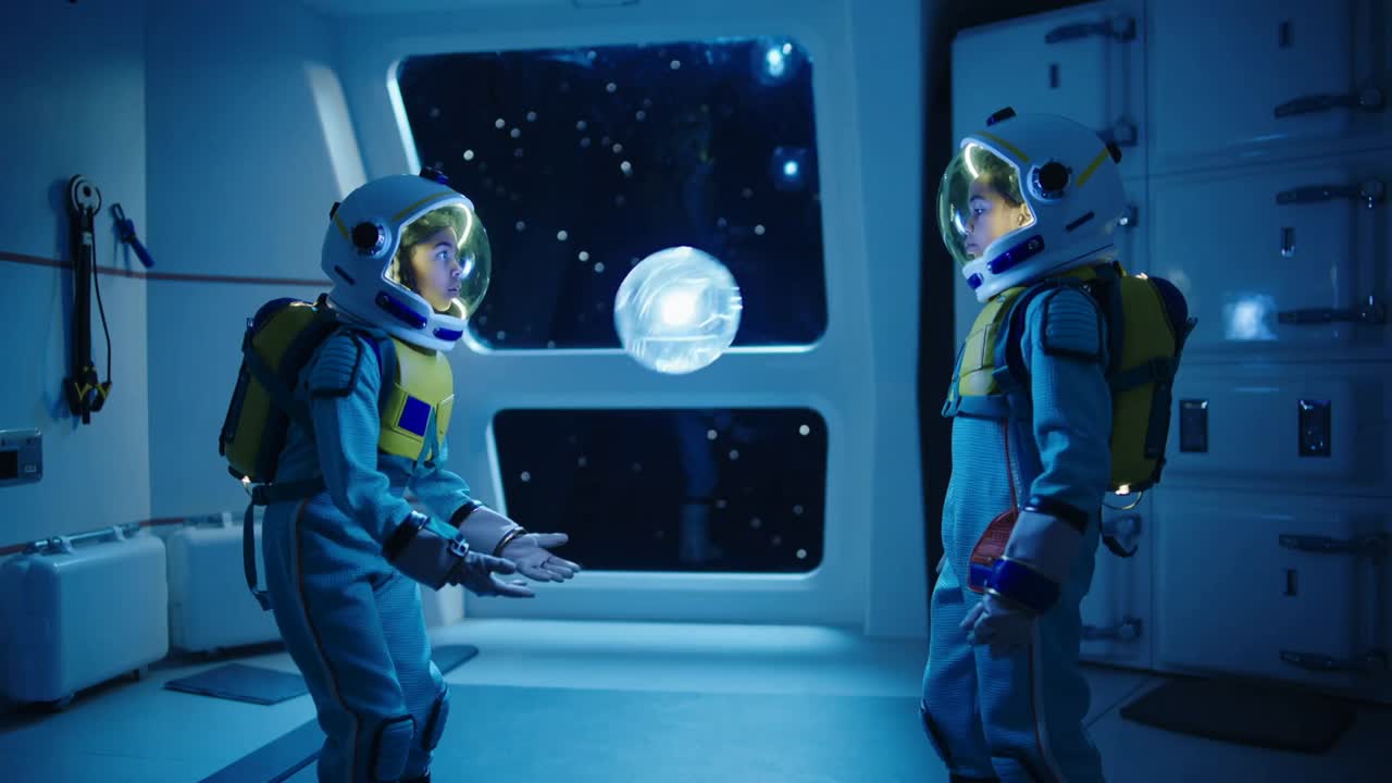 Presenting left child releasing floating orb while two kids in blue suits training balance in cabin