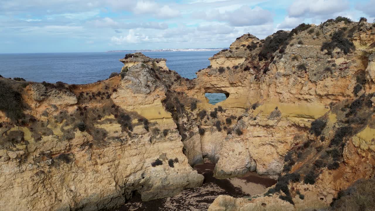 Aerial view of coastal cliffs in Portugal, with rugged rock formations and ocean in the background