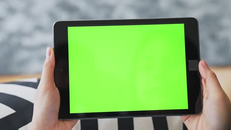 close up de mujer sosteniendo en las manos una tableta digital con pantalla verde para internet en línea, pantalla clave de croma para publicidad.