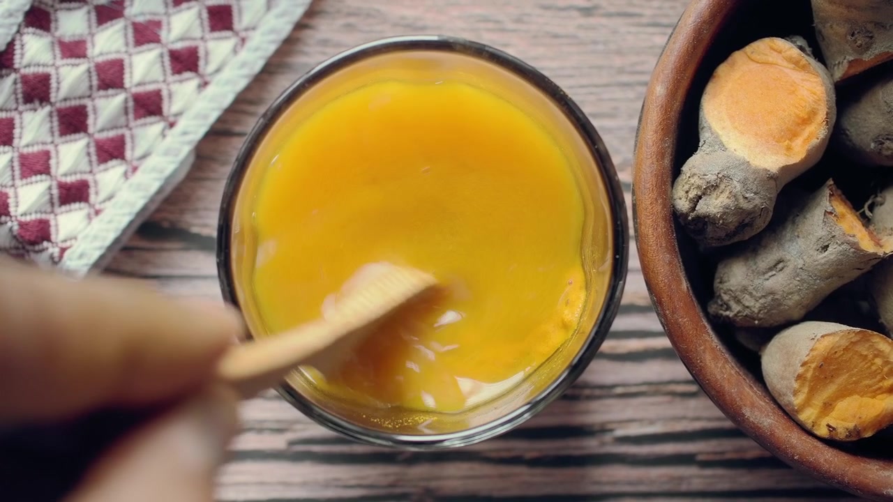 Stirring Turmeric Powder into Water in a Glass