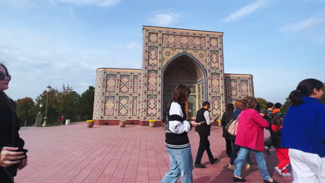 people and tourists walking past a historically decorated building