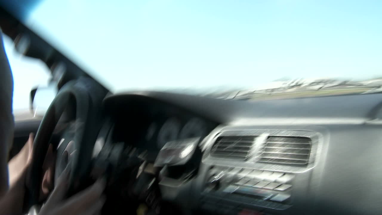 트랙에서 테스트 드라이버가 표류하는 동안 기동을 통해 자동차 내부에서 pov 샷을 찍습니다.