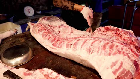 expert butcher cuts and trims pork loin