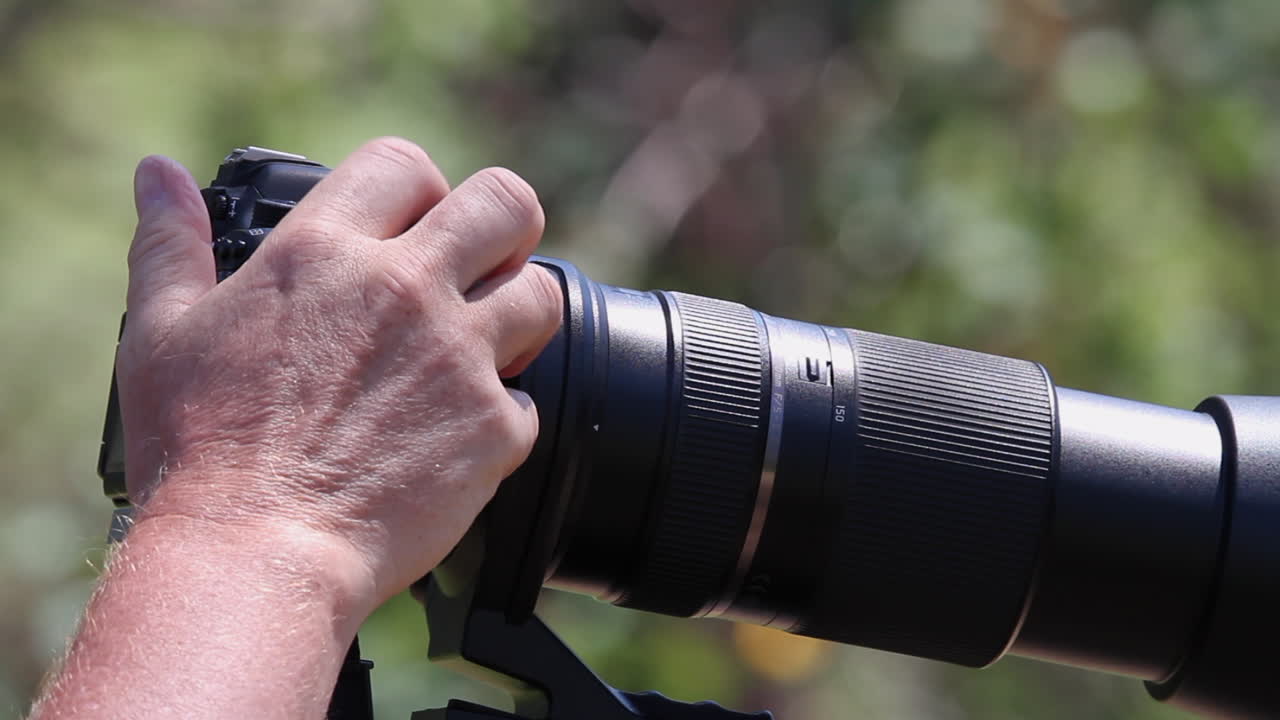 Full frame close-up camera with large zoom lens, photographer's hand