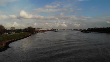 scenic view with cargo vessels sailing across quiet river of oude maas in the city of zwijndrecht, netherland