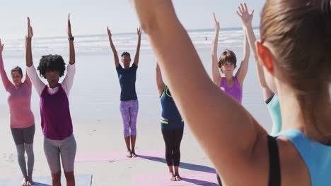 Multiethnische-Gruppe-Von-Frauen,-Die-Yoga-Position-Am-Strand-Und-Im-Hintergrund-Des-Blauen-Himmels-Machen