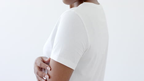sección media de una mujer afroamericana vestida con una camiseta blanca con espacio de copia en un fondo blanco