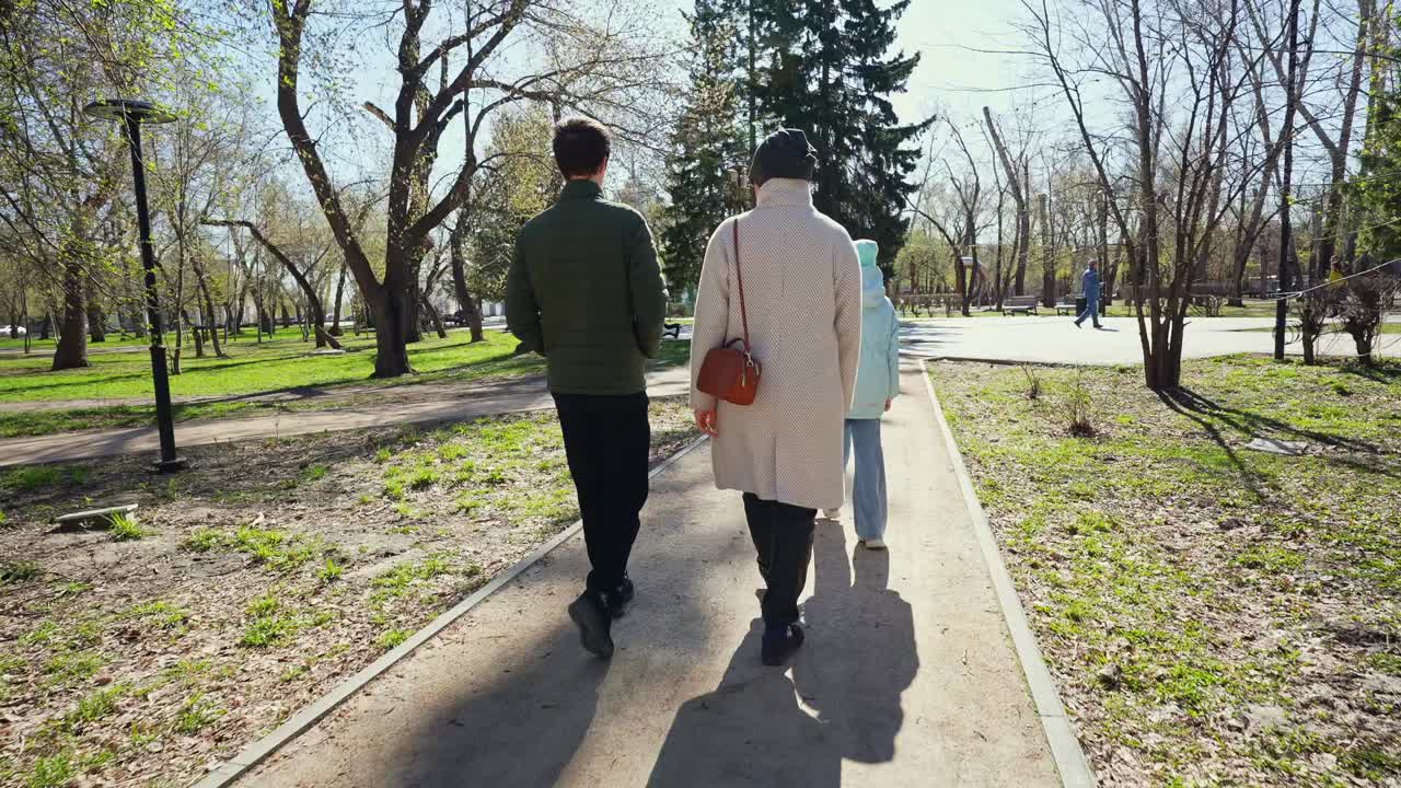 一家人在阳光明媚的公园里散步