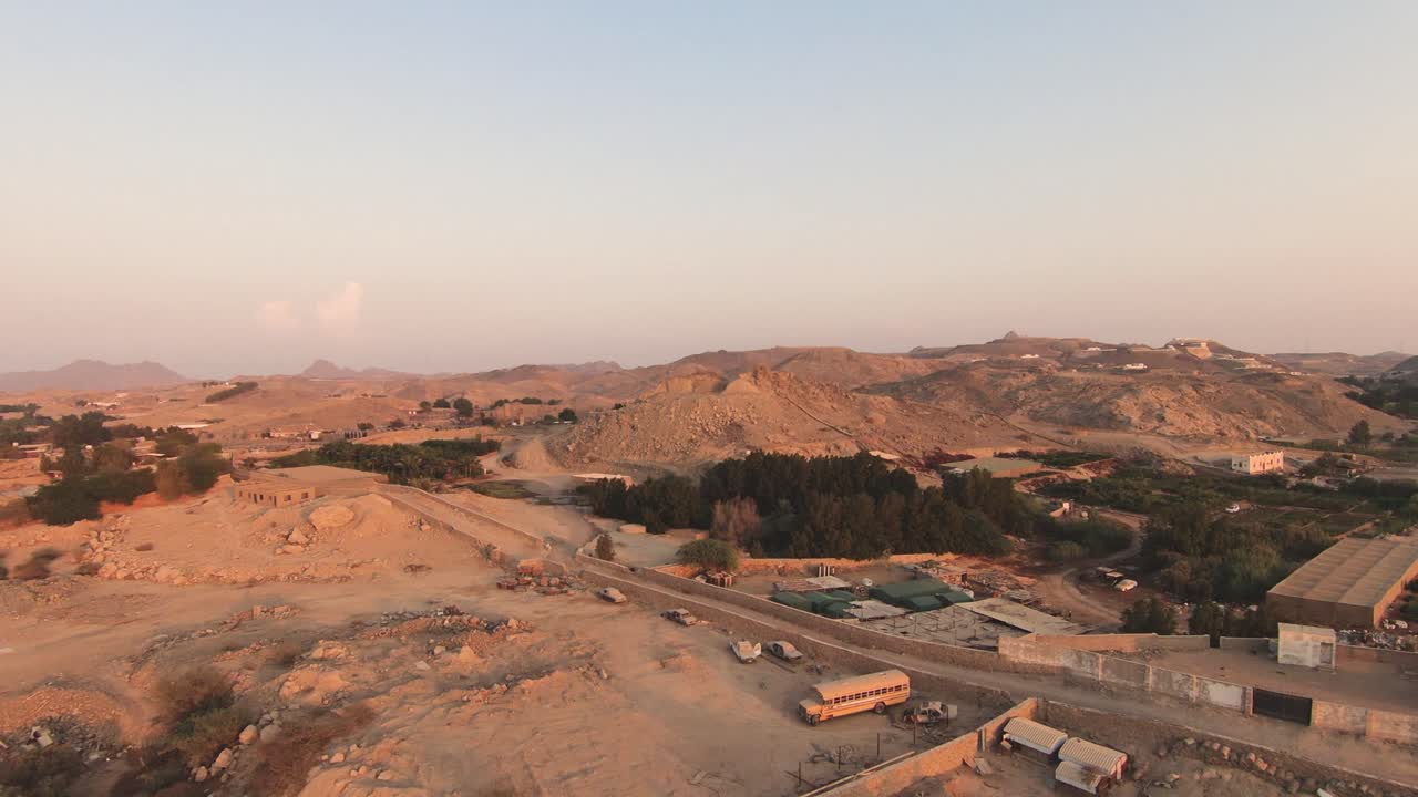 먼 언덕 사우디 아라비아를 향해 녹색과 모래 지역을 비행하는 fpv