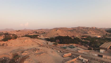 fpv volando sobre una zona verde y arenosa hacia colinas lejanas arabia saudita