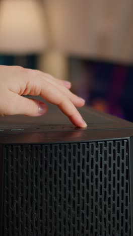 vertical video: professional esports gamer pressing on start button of computer unit