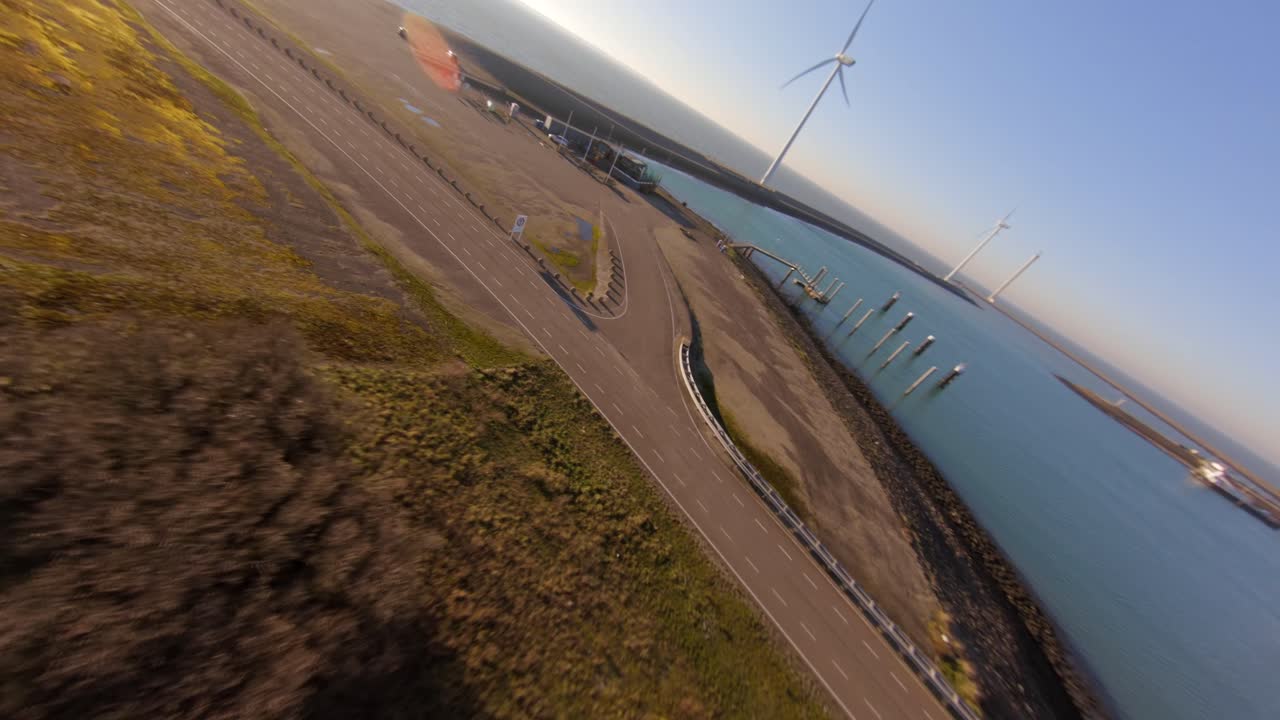 Fast aerial shot following a road on a dyke on the island Neeltje Jans