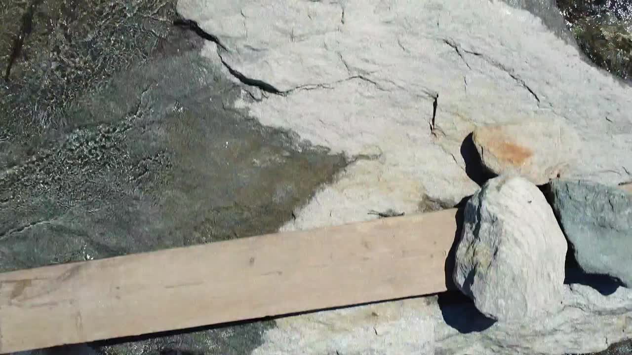 바위가 많은 오스트리아의 물줄기 위로 낮게 날아가는 모습