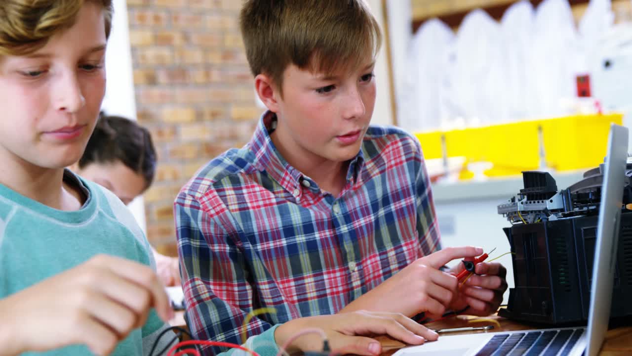 교실 에서 전자 프로젝트 를 하는 학교 소년 들