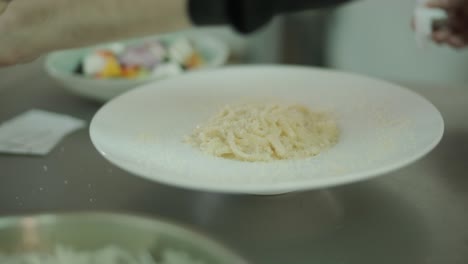 셰프가 야외 그릴에서 새우와 함께 파스타를 요리하고 있습니다.