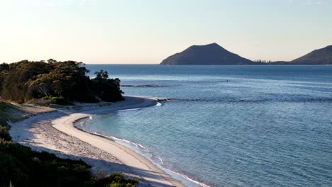 a mountain with a body of water in the background and trees in the foreground, and a body of water in the foreground