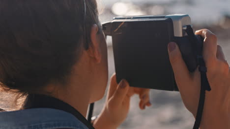 Una-Joven-Fotógrafa-Tomando-Fotos-En-La-Playa-Usando-Una-Cámara-Retro-Disfrutando-Del-Día-De-Vacaciones-De-Verano.-Una-Joven-Fotografiando-Una-Hermosa-Playa.