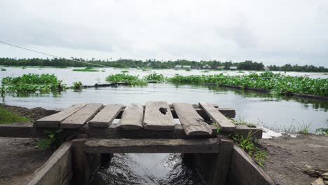 Transporte-De-Agua-En-La-Acuicultura,-El-Agua-Fluye-Con-Fuerza-A-Través-De-La-Compuerta,-Se-Dispara-A-Través-De-La-Compuerta,-El-Agua-Llega-A-La-Granja-Acuícola