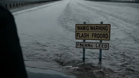 flooded road with warning signs