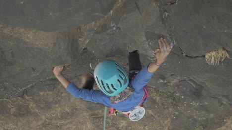 joven asiática intentando escalar un hermoso pináculo en un día soleado, de cerca