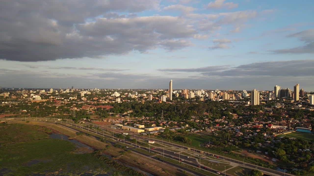 Aerial view of the city during late afternoon, with the skyline illuminated by soft golden light. Green city. Asuncion. Paraguay