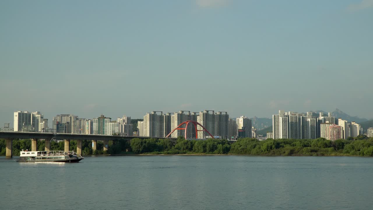 페리 유람선은 밤섬을 따라 서강교에서 서울의 고층 아파트 건물과 북한산을 배경으로 한강을 따라 이동하며 낮에는 관광