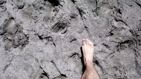 hombre caminando descalzo en la playa de arena, punto de vista, cámara lenta