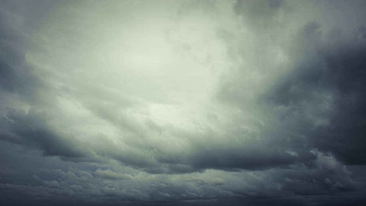 Developing tropical storm during monsoon season over the open ocean, with swirling cloud formations, turbulent winds, and dramatic weather patterns above dark-colored sea waters