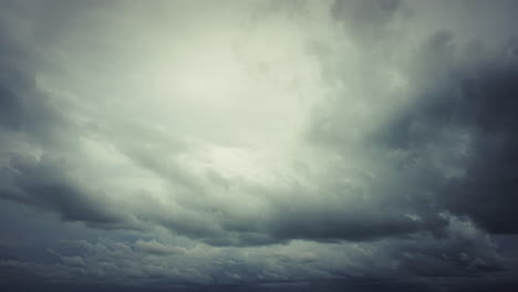 developing tropical storm during monsoon season over the open ocean, with swirling cloud formations, turbulent winds, and dramatic weather patterns above dark-colored sea waters
