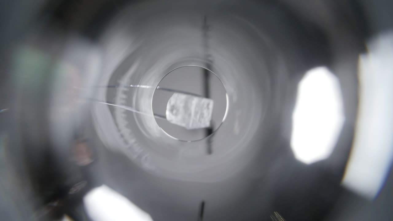 Ice cube falling into glass and covering camera lens close up worms eye view