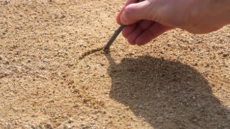 Drawing-heart-in-gold-sand