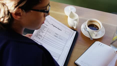 businesswoman doing paper work in cafe