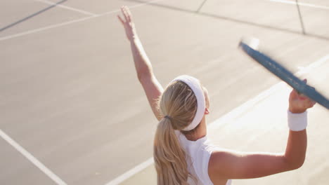 video of back of caucasian female tennis player holding racket and hitting ball