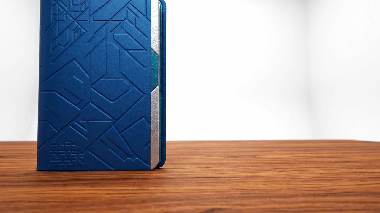 Elegante quaderno blu su superficie di legno: una vista ravvicinata che cattura il design intricato e l'estetica elegante di un essenziale di cancelleria moderno.