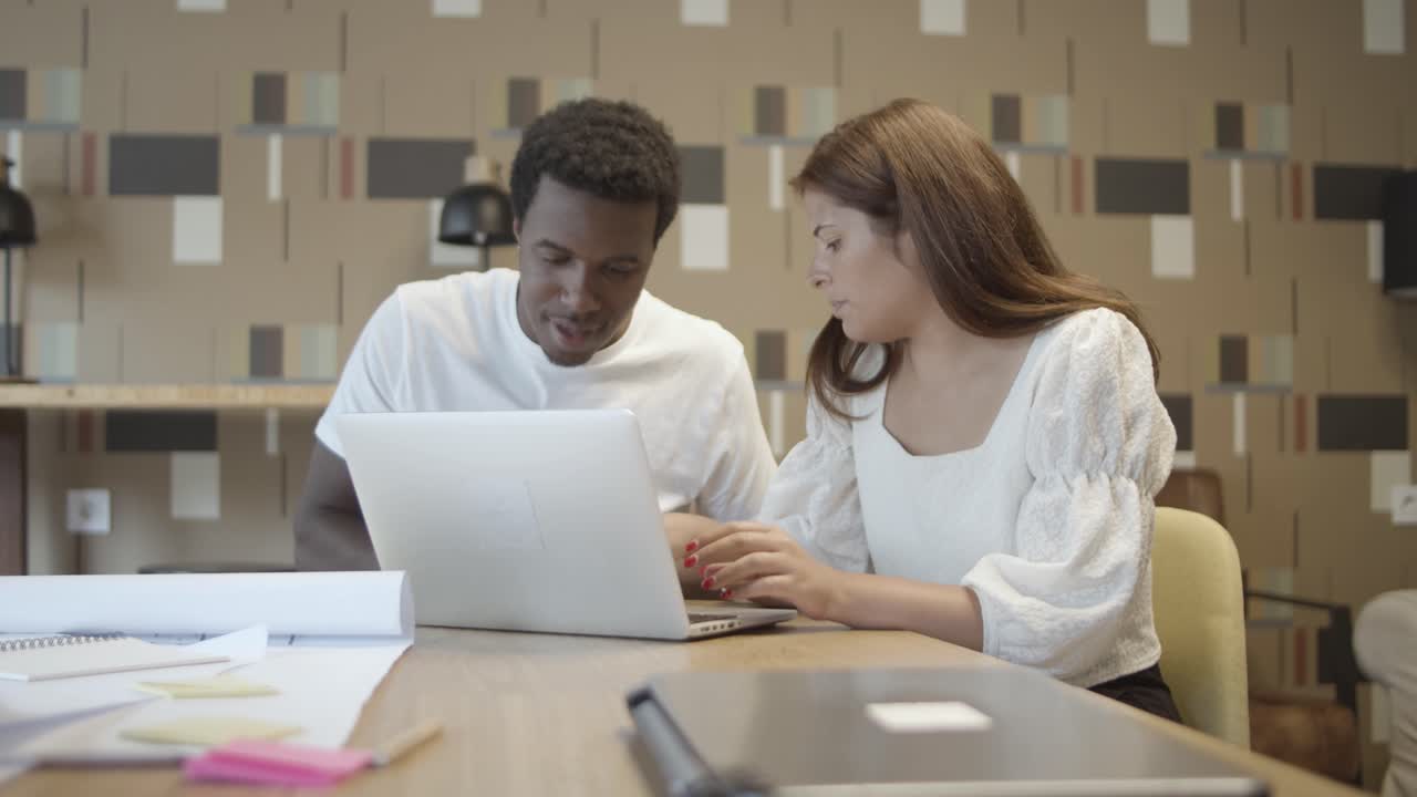 jóvenes colegas serios trabajando juntos