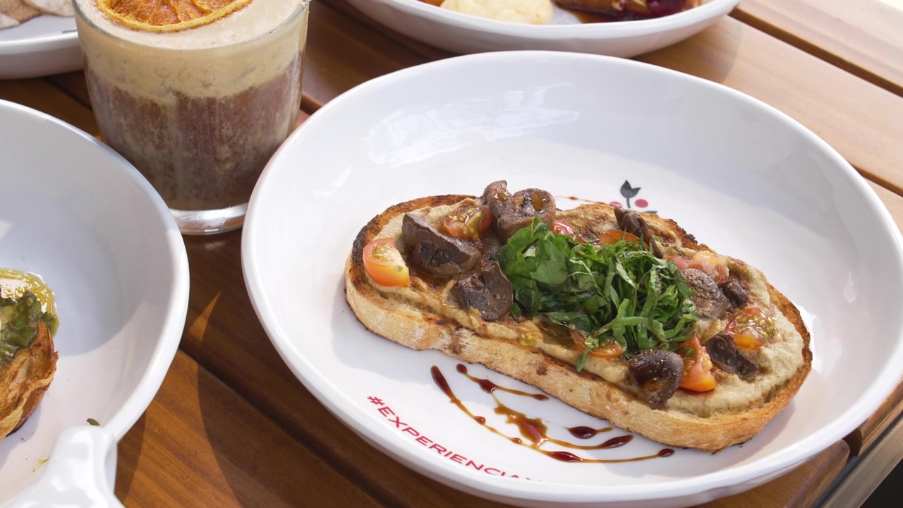 Esperienza culinaria informale con bruschetta italiana fresca e piatti colorati per il brunch al ristorante.