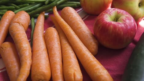 fresh cucumbers, apples, green beans and carrots on a kitchen counter