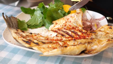 grilled fish with salad and lemon