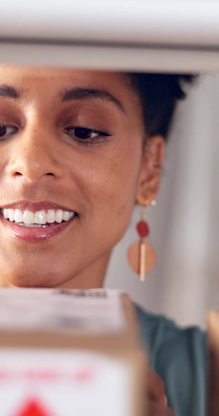 Donna sorridente che apre un pacco consegnato