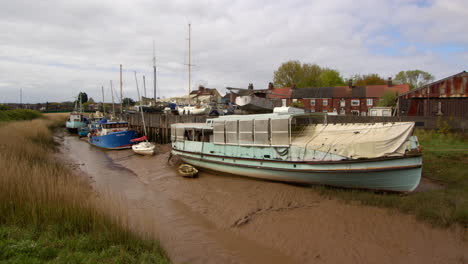 wide shot showing boats at low tide on the barton haven river stream